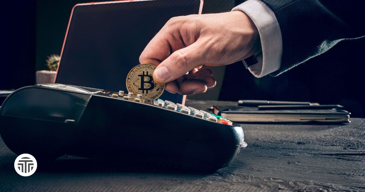 Insertando una moneda con el logo de Bitcoin en una caja registradora